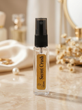 Perfume bottle labeled 'Secret Crush' on a reflective surface with decorative items in the background