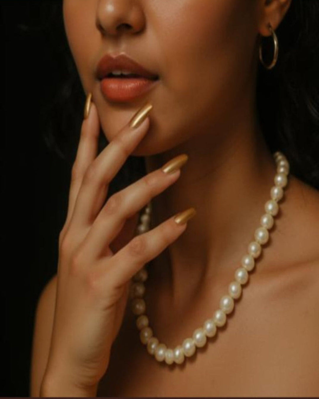 Woman wearing a pearl necklace with a dark background