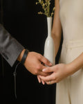 Two people holding a white vase with a blurred background